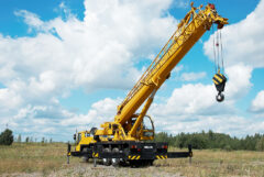 yellow automobile crane with risen telescopic boom